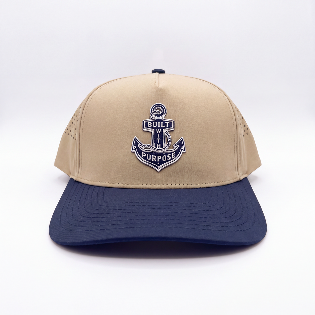 Sand and navy-blue baseball cap with centered anchor patch and curved brim